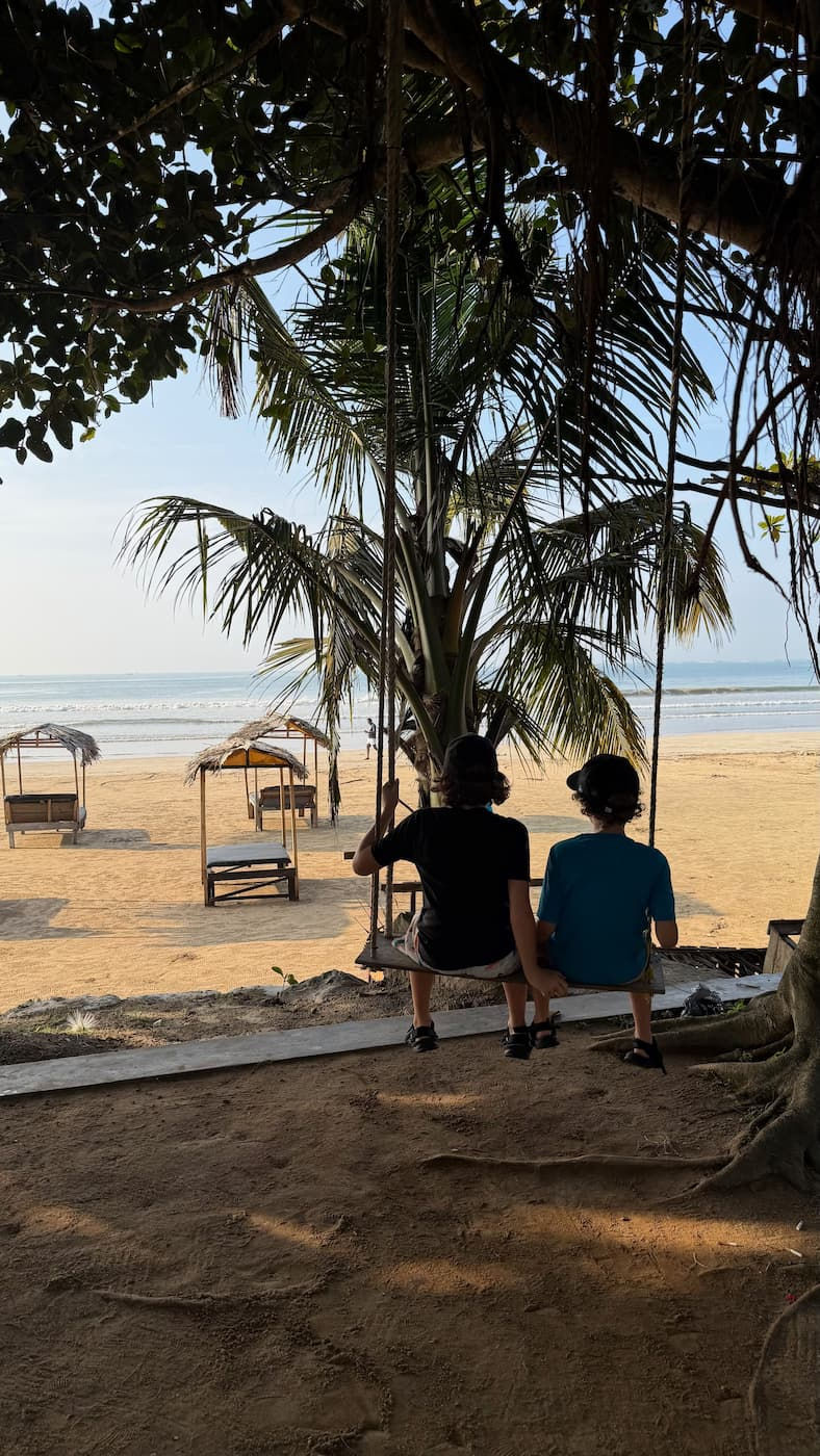 boys-sitting-on-swing-looking-onto-the-sea-in-weligama-sri-lanka