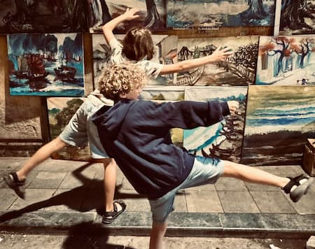 kids-in-hanoi-making-funny-poses-in-front-of-artistic-wall-with-pictures