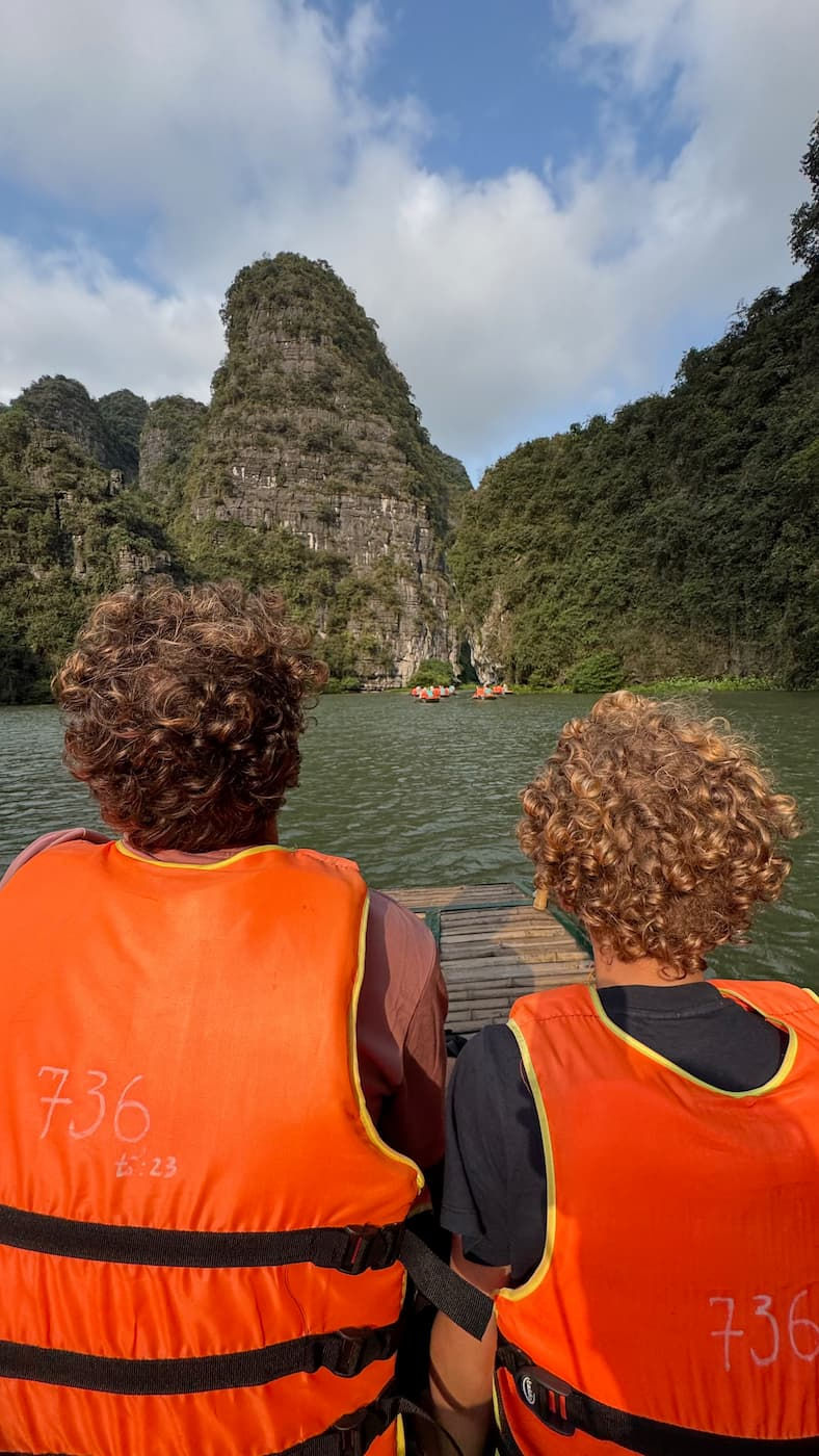 father-and-son-sitting-on-trang-an-boat-tour-looking-in-the-distance-ninh-binh-vietnam
