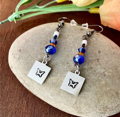 Beautiful matching earrings with butterfly charms, blue beads and a pop of white and orange! Grab a set today! 