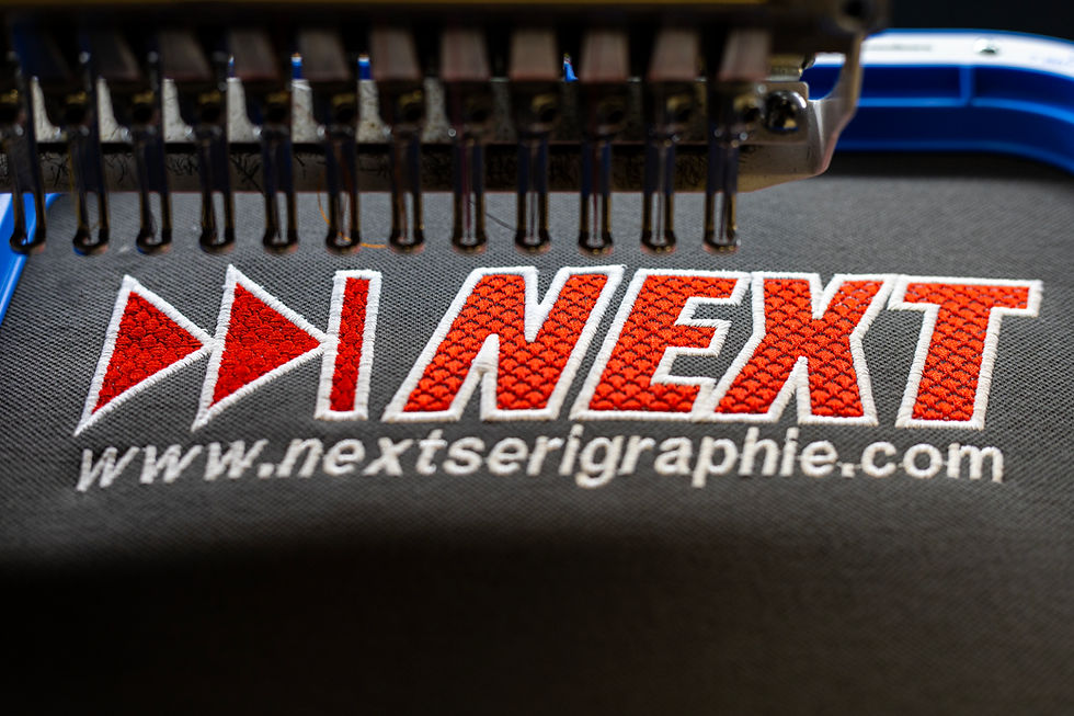 Gros plan d'un logo Next brodé sur un textile dans les ateliers frrançais de broderie