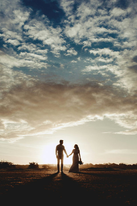 Silhouette des mariés marchant main dans la main au coucher du soleil, séance photo de mariage poétique en Centre – Val de Loire au Domaine de Vacheresses (28)