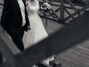 Photo noir et blanc d'un couple de mariés marchant sur un pont