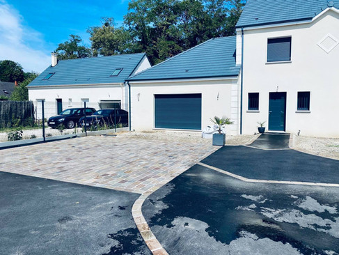 Entrée de maison à Savigny-le-Temple avec pavage en pierre naturelle et goudronnage réalisé par Pim’s Revêtements, spécialiste des revêtements extérieurs en Seine-et-Marne