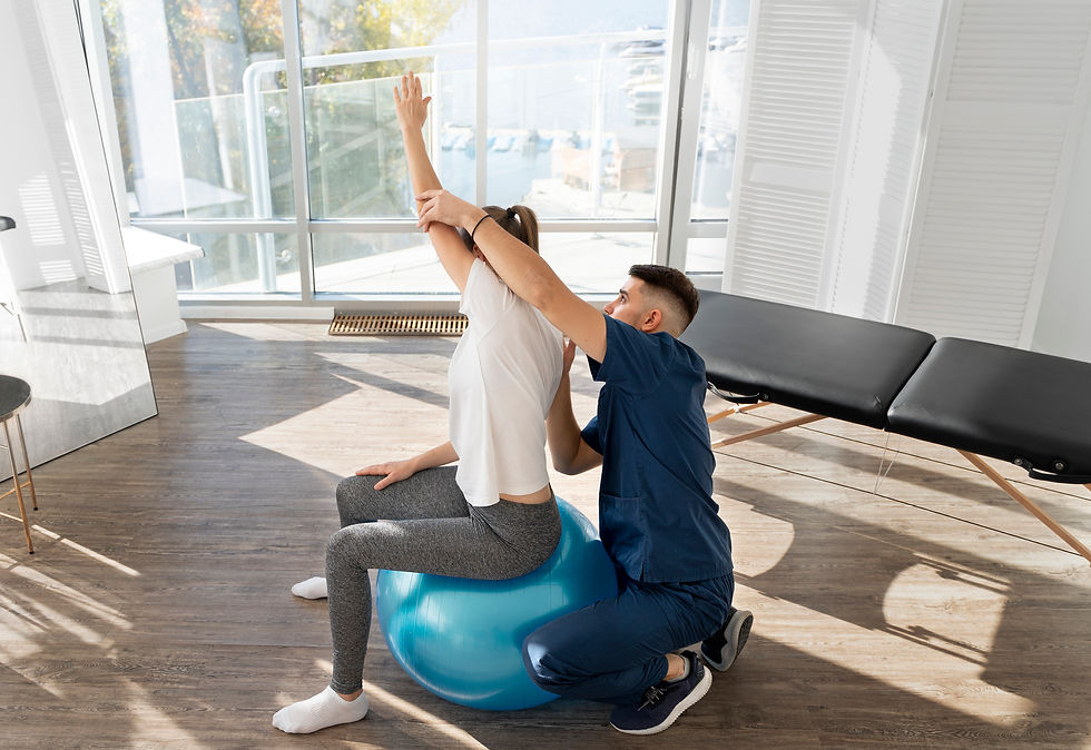 Woman performing rehab exercises with gym ball at physical therapy clinic
