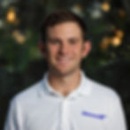 David Frank smiling outdoors wearing a white polo shirt