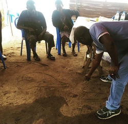 Dr. Komi Folly explaining medical condition to patient by drawing on the ground at 2016 Togo medical