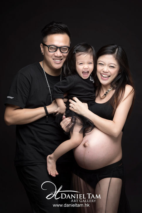 family maternity photoshoot in black background