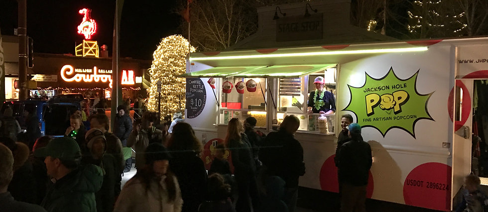 The Kernel, Jackson Hole POP's popdorn food truck at Rendezvous Festival's concert with the Million Dollar Cowboy Bar and Antler Arches in the background