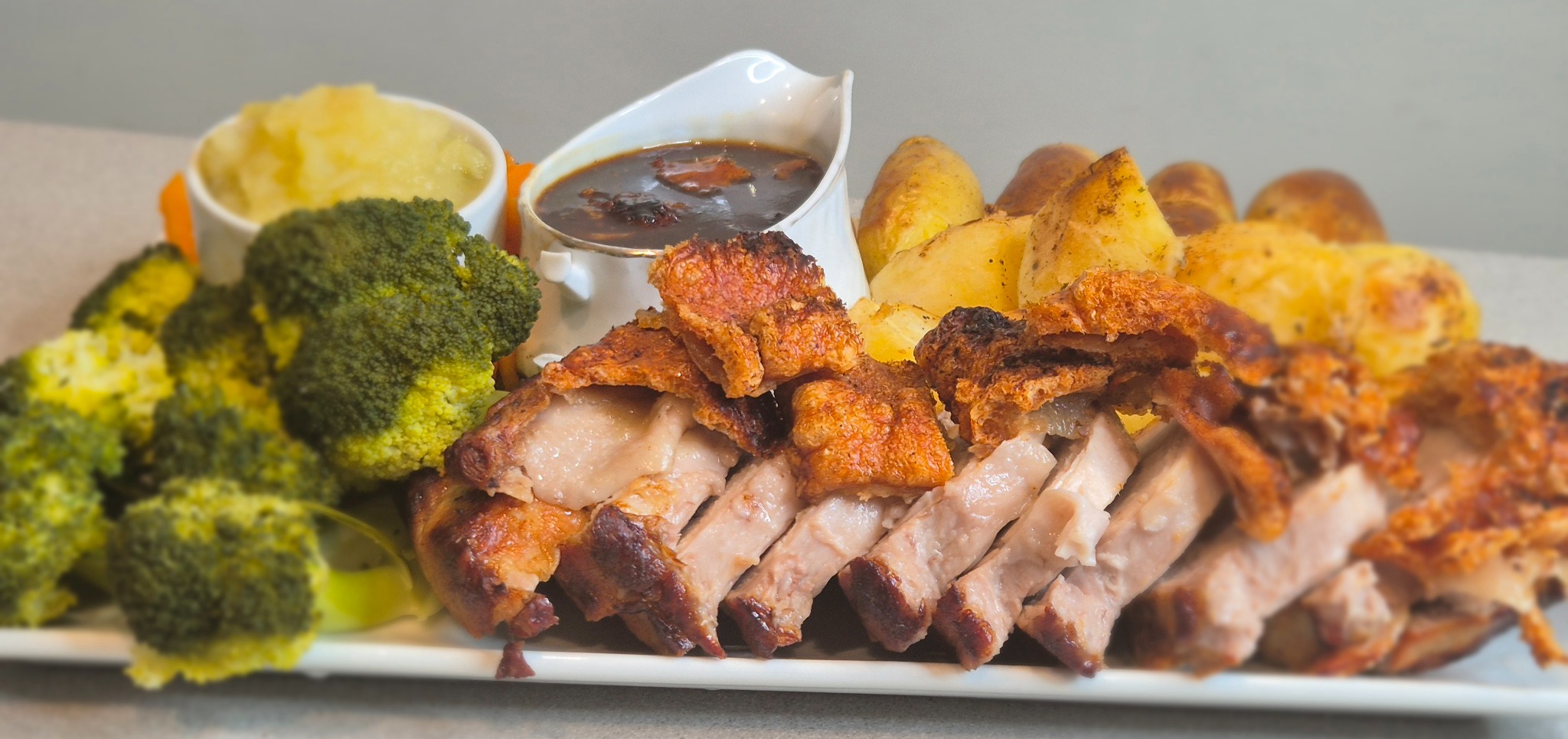 Noba Kitchen sharing feast platter with sliced roast meat, golden potatoes, broccoli and gravy.