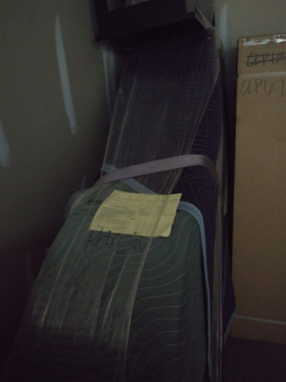 wrapped up piano being moved by movers