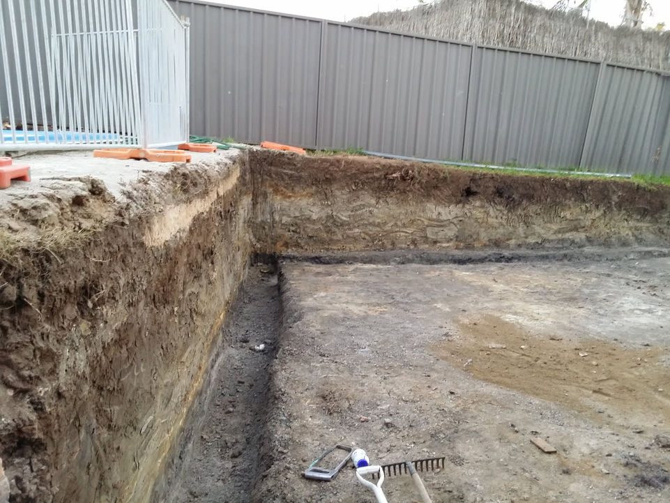 Retaining wall preparation using excavator on residential property