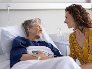 A adult women visits her elderly mother in the hospital. 