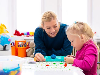 An occupational therapist works with a young girl.