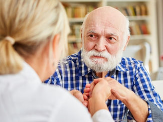 A women speaks kindly with her elderly father.