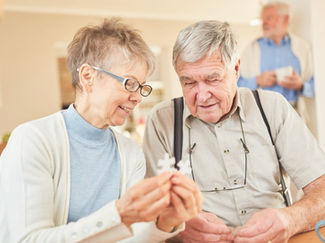 An elderly couple works on a puzzle together.