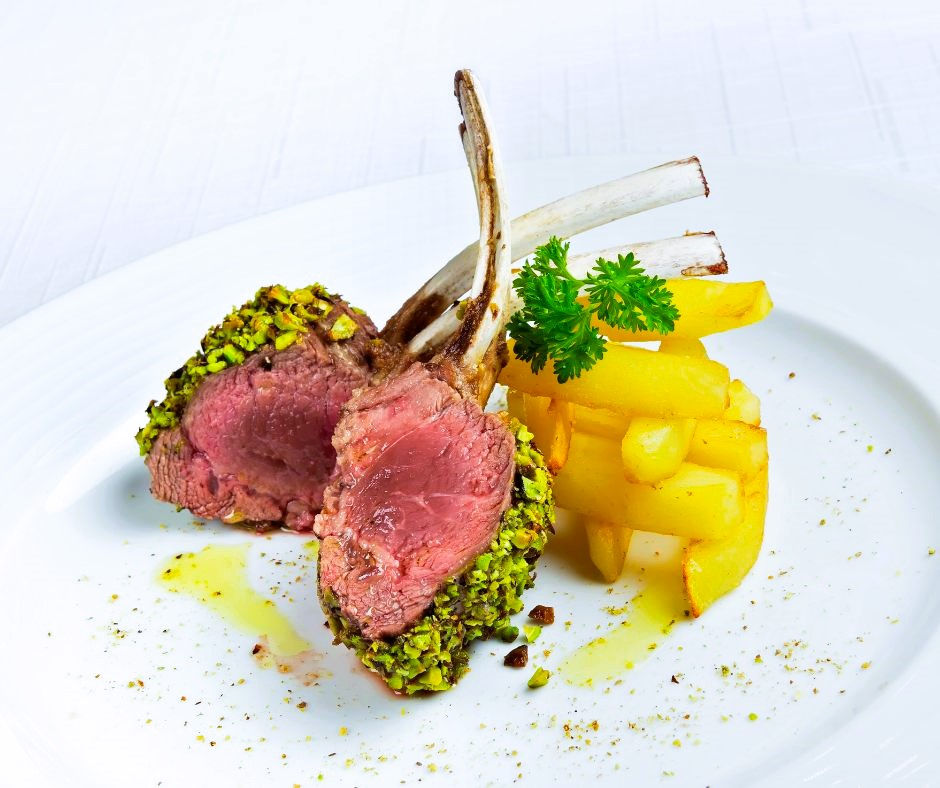 Miniatura: Lammkarree rosa gebraten mit Gemüse angerichtet