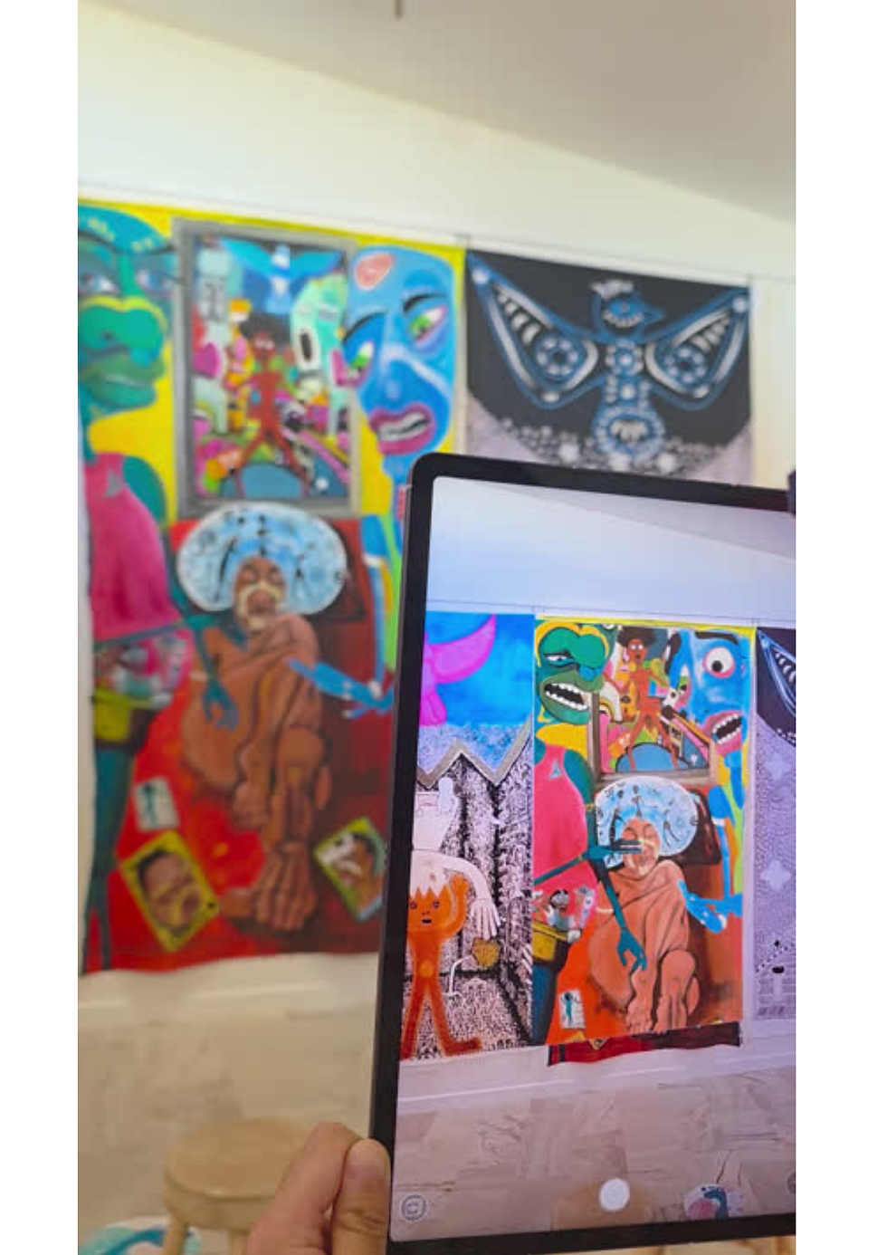 Photo of gallery visitor observing an AR moving image overlay interacting with a physical artwork. Title of Artwork: Visitors Came: After the Rain, by Kat Bell (2025) created for The Legacy of Trevor Nickolls Exhibition Oct-Nov 2025.