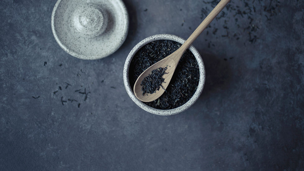Loose leaf tea in a bowl with wooden spoon