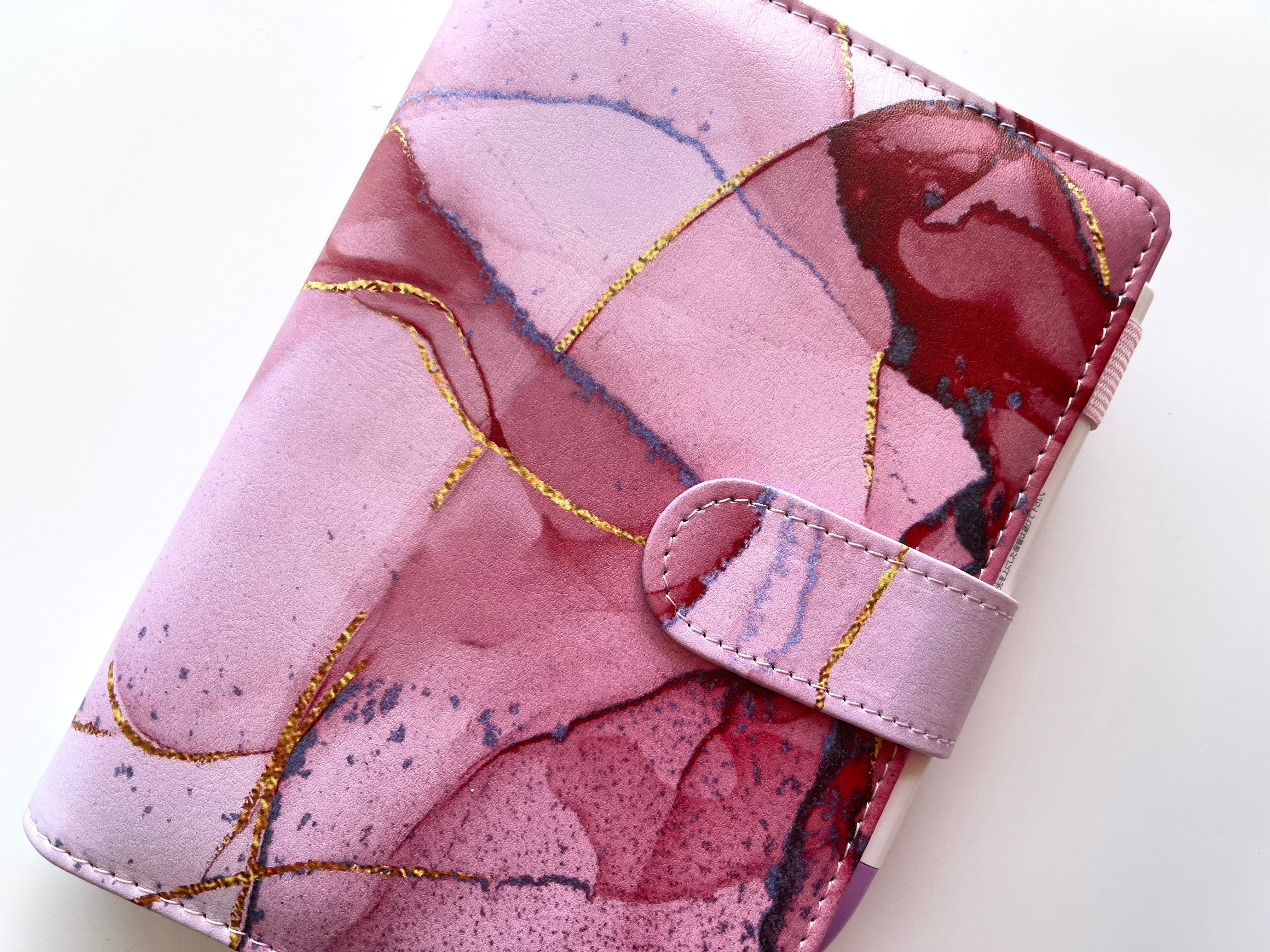 Pink marble A5 budget binder with vegan leather cover and magnetic closure.