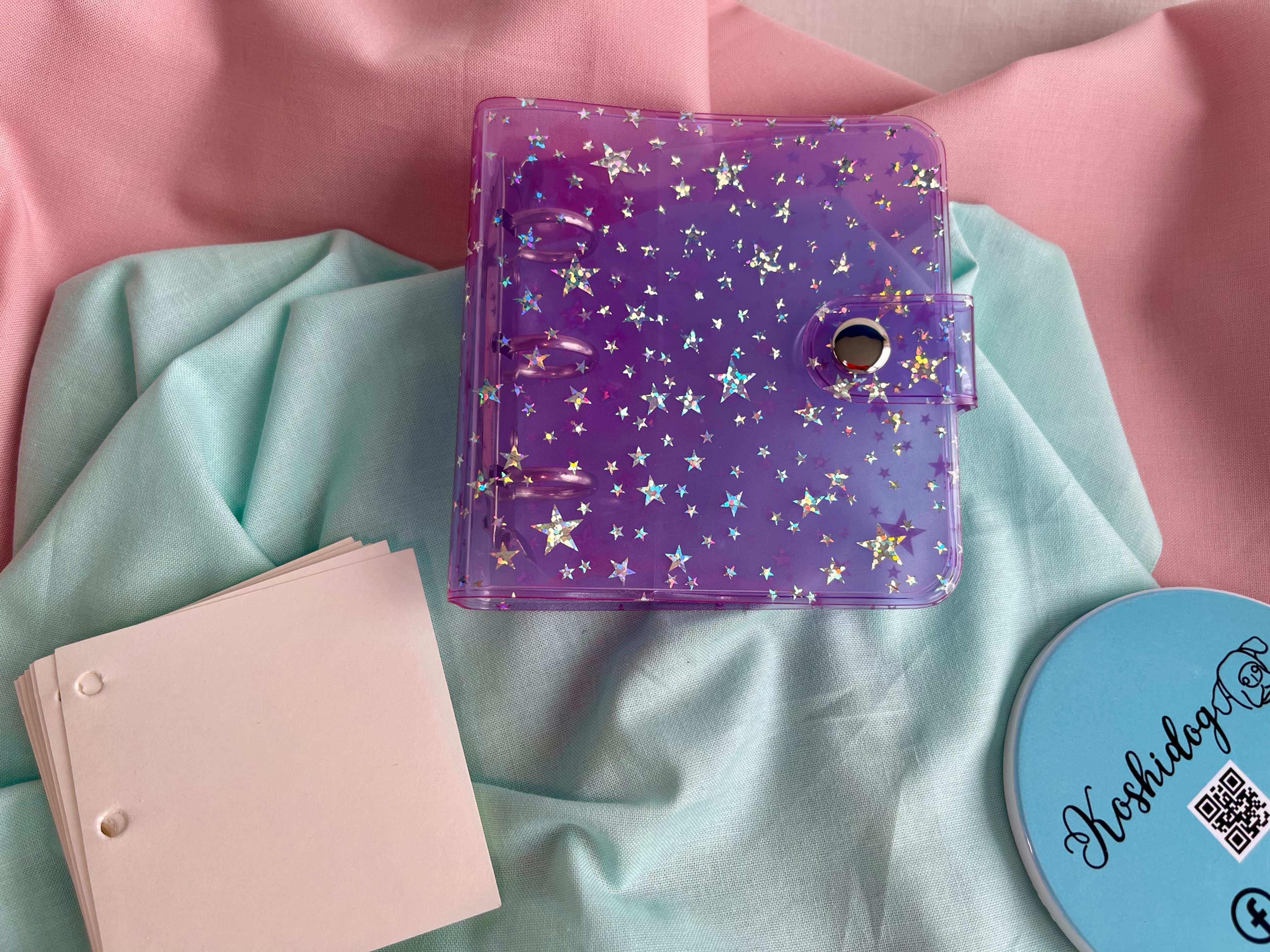 Tiny purple stars mini binder with plastic cover and secure clip closure.