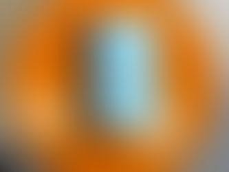 A closed blue and black book resting on a round orange table.