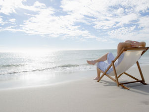 אישה על כסא נוח בחוף ים