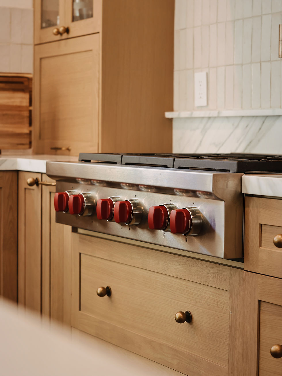 Wolf gas range with red knobs in a modern kitchen