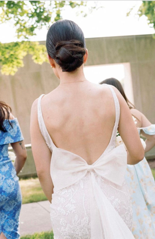 Bride with updo bun by Romany at outdoor wedding