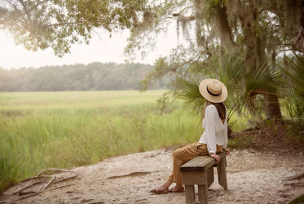 woman-sitting-on-bench-near-forest-and-g