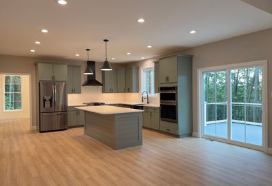 Kitchen island with sage cabinets and white countertops