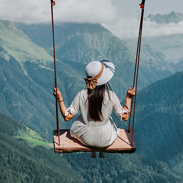 Frei Sein und frei leben - Frau schaukelt über Berge hinweg