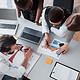 Bello personale elegante seduto in ufficio alla scrivania utilizzando un computer portatil