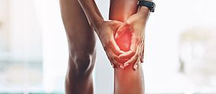 Hands, pain and knee injury with a woman in studio holding an injury to her joint while tr