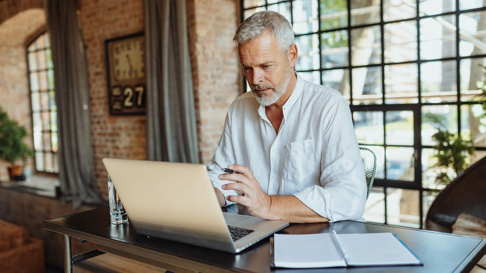 A property owner reviews documents and manages tasks from a laptop in a stylish, sunlit office space.