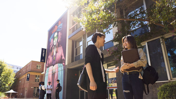 two students talking outside college campus