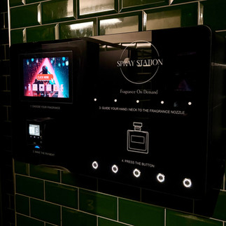Wall-mounted Spray Station fragrance vending machine UK operating inside a club bathroom.