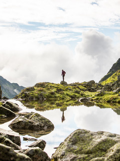 Reflektierende Person im Bergsee vor der Leutschachhütte