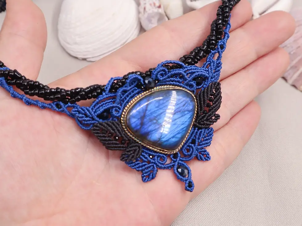 Miniature : Gros plan sur la labradorite bleue du collier Murmure abyssal, entourée d’un tissage en macramé.