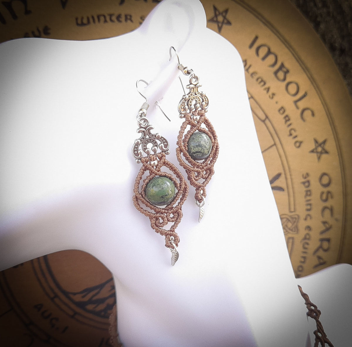 Boucles d'oreilles tissée à la main en macramé, bijou artisanal avec jaspe kambaba, mis en scène dans la forêt