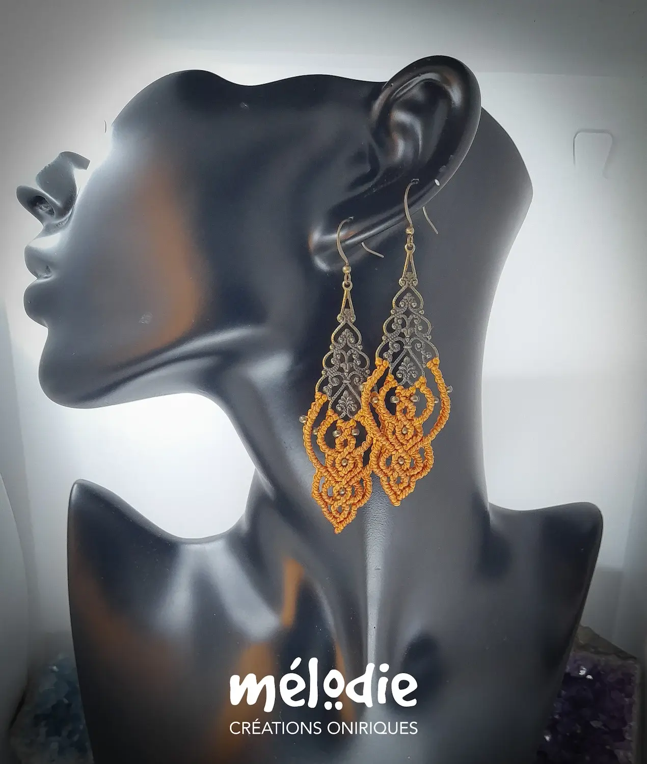 Boucles d’oreilles macramé orange safran Althéa bronze portées sur buste noir
