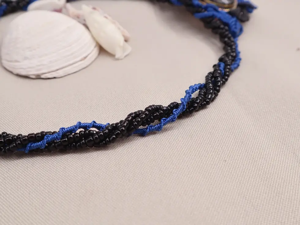 Miniature : Détail du tour de cou du collier Murmure abyssal avec perles de rocailles noires et tissage bleu en macramé.