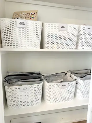 Games and puzzles organized by Neat Nathalie in white bins for maximum space and storage efficiency.