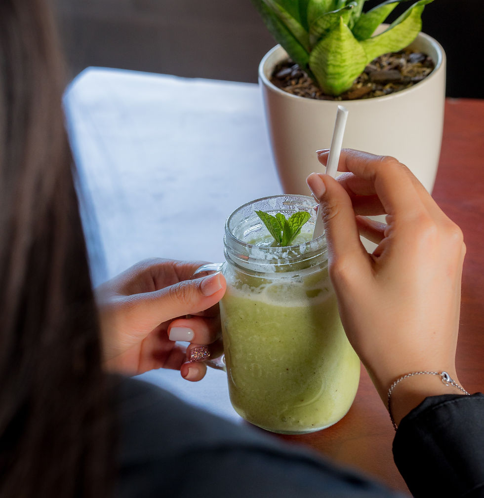 Person holding a glass of fresh green vegetable juice