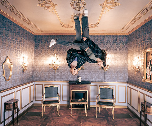 Ein Pärchen steht kopfüber in der Kulisse vom Königssaal im Erlebnismuseum München
