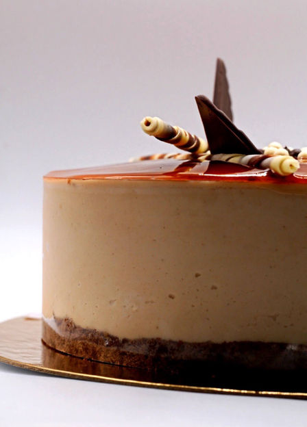 Close-up of coffee cake slice topped with caramel glaze and chocolate topping