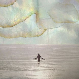 woman in ocean under pearly mystical skies, symbolizing the cosmic womb energy of the Pisces New Moon March 2026