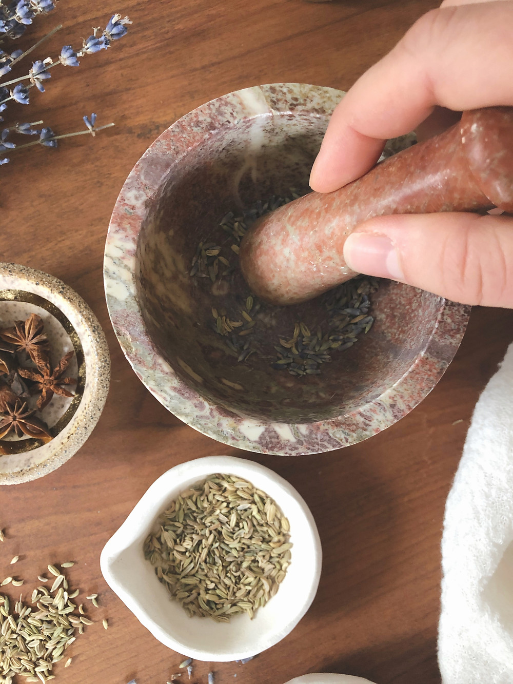 grinding up herbs in stone mortar and pestle