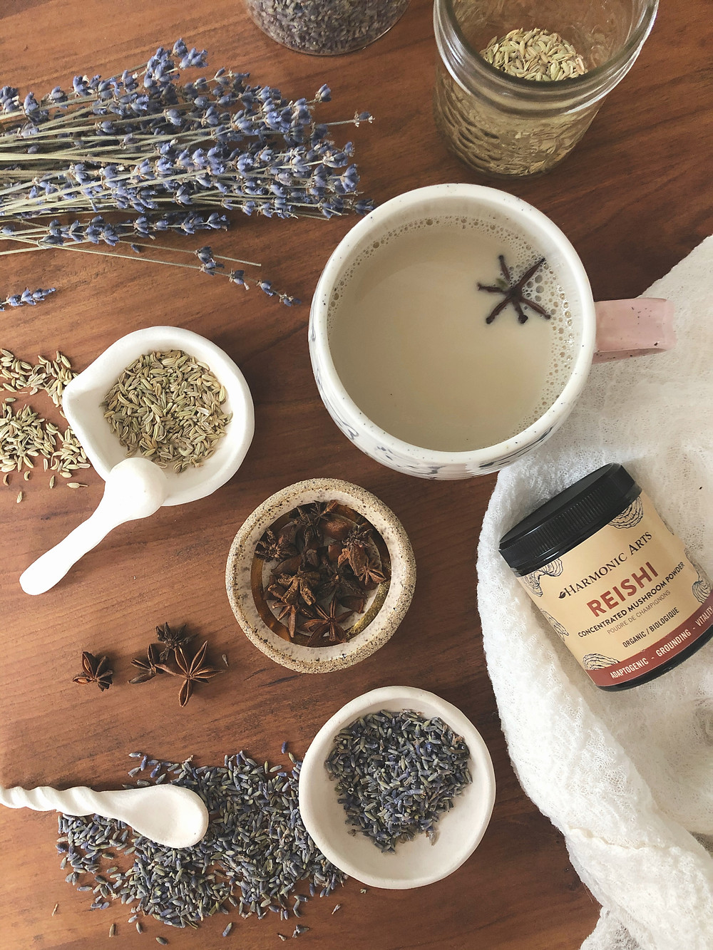 harmonic arts reishi powder, loose fennel, lavender and star anise on table with oat milk infused with herbs for mercury retrograde
