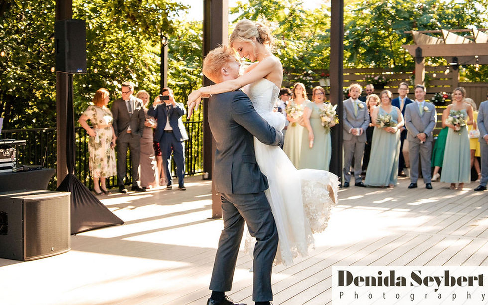 High angle view of a small outdoor wedding reception with string lights and rustic wooden tables